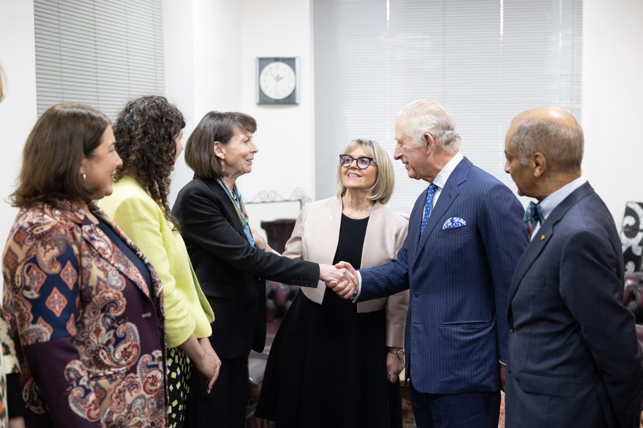 HM The King shakes hands with Rebecca Tinsley, President and Founder of Waging Peace © Sam Churchill