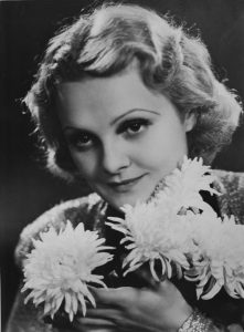 Black and white photo of Vali Rácz, holding some flowers
