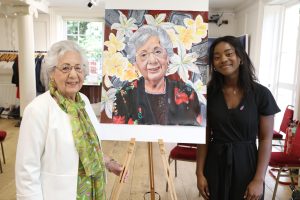 A photo of Helen Aronson BEM and Nancy Akuffobea with the portrait Nancy painted of Helen