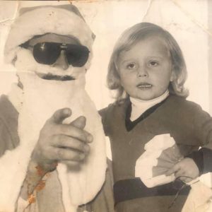 An old photo of Sanela as a young child being held by someone dressed up as Father Christmas