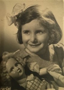 An old photo of Yvonne as a young girl, holding a doll